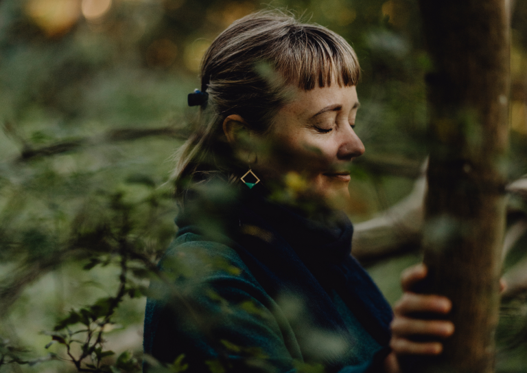 Frau in der Natur nimmt sich Zeit für sich bei einem Frauenretreat Soft & Wild together